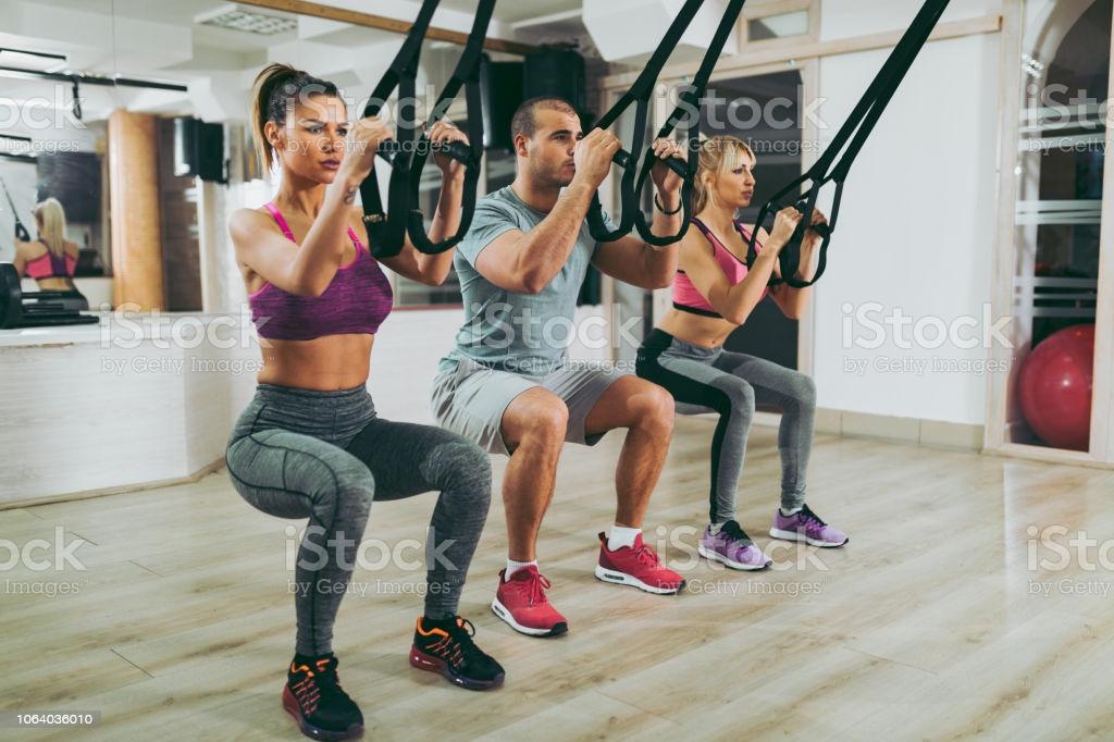 Suspension training people doing arm and leg exercises picture id1064036010